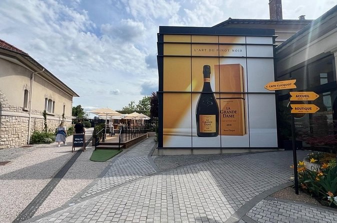 A pavilion with a giant La Grande Dame bottle poster, yellow signposts beside it