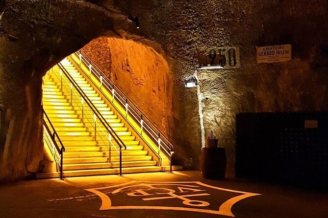 A lit staircase descending into a chalk pit, the house emblem laid out on the floor below