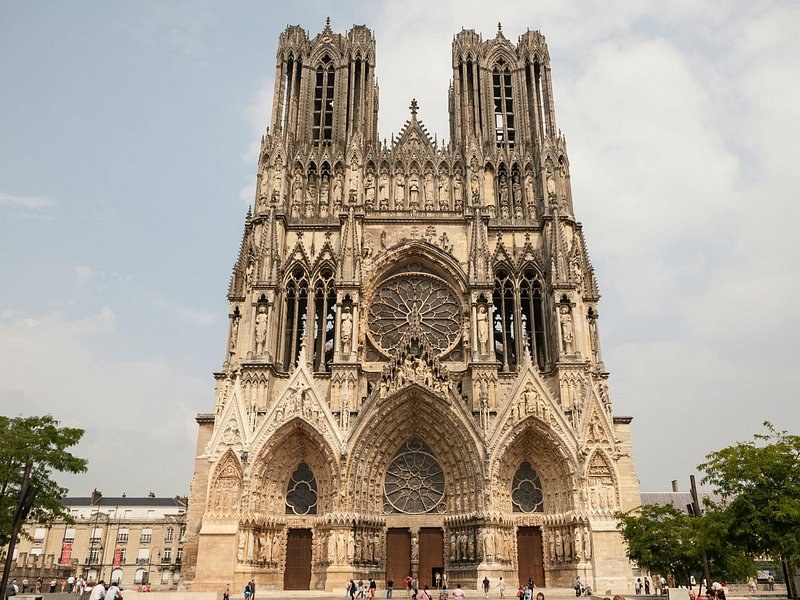Reims Cathedral's west front and its two towers under a pale sky