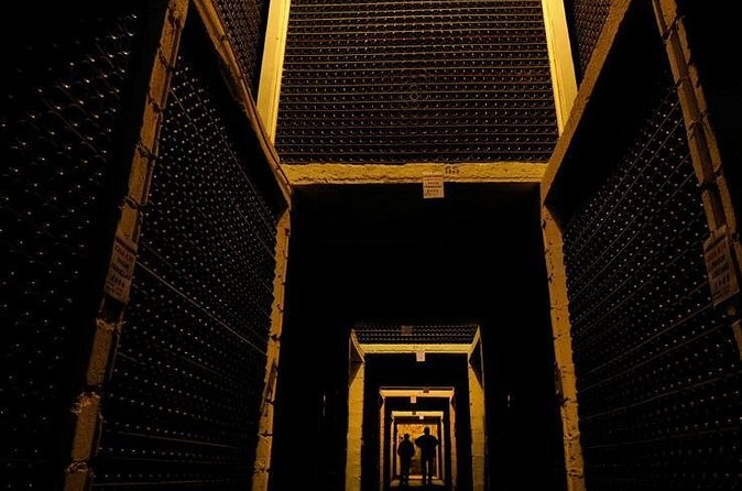 A narrow passage between tall racks of bottles, lit at the far end
